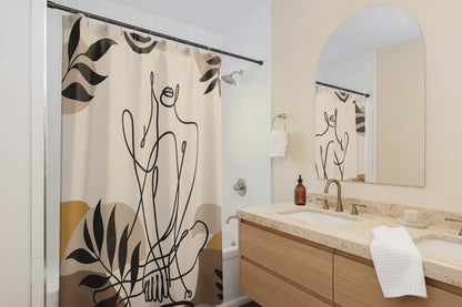 A beige shower curtain with a black minimalist line art design of a figure and leaves, hanging in a modern white and blue-gray bathroom.